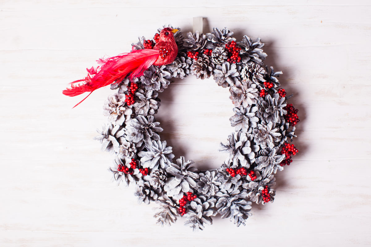 Christmas wreath with white pine cones and red berries, perfect for a shabby chic decoration.