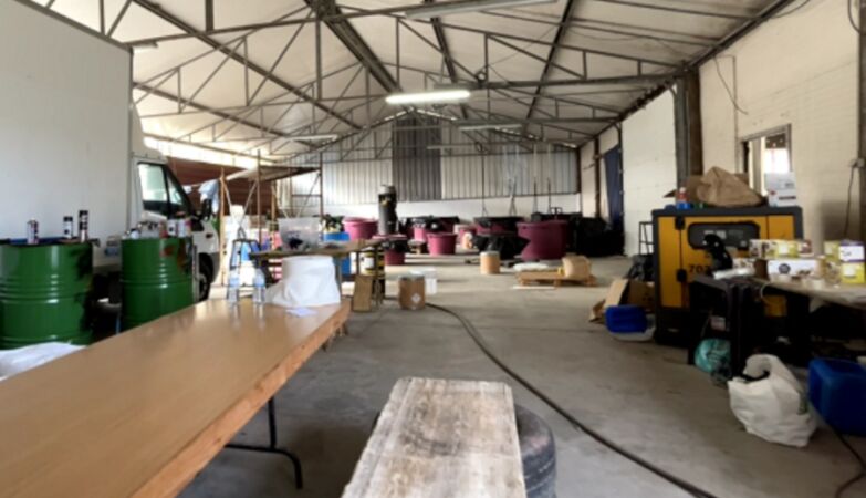 Warehouse with a table and various materials and a ceiling with gray beams where a cocaine laboratory operated.
