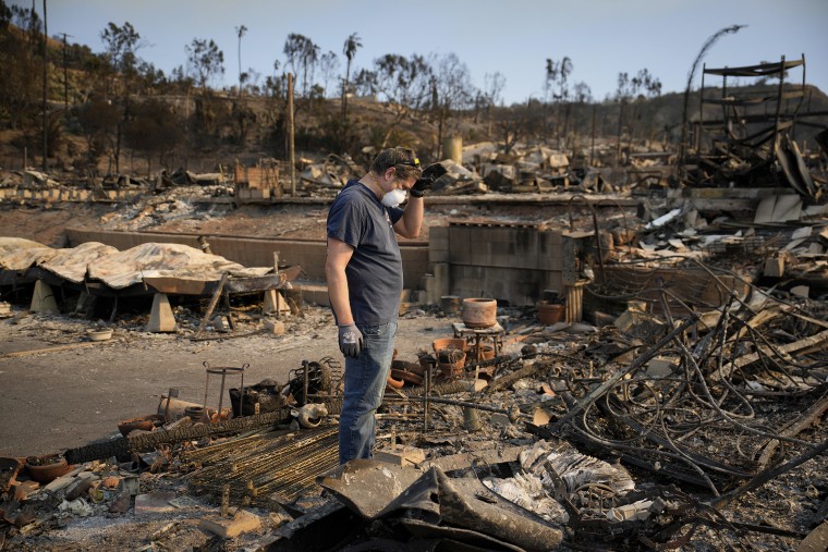 Kevin Marshall sifts through his mother’s fire-ravaged property in the Pacific Palisades neighborhood on Saturday.