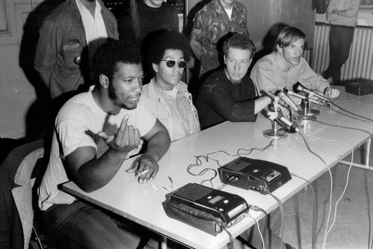 From left, sitting at a table, Fred Hampton, Pablo "Yoruba" Guzman, Jose "Cha-Cha" Jimenez, and Mike Klonsky.