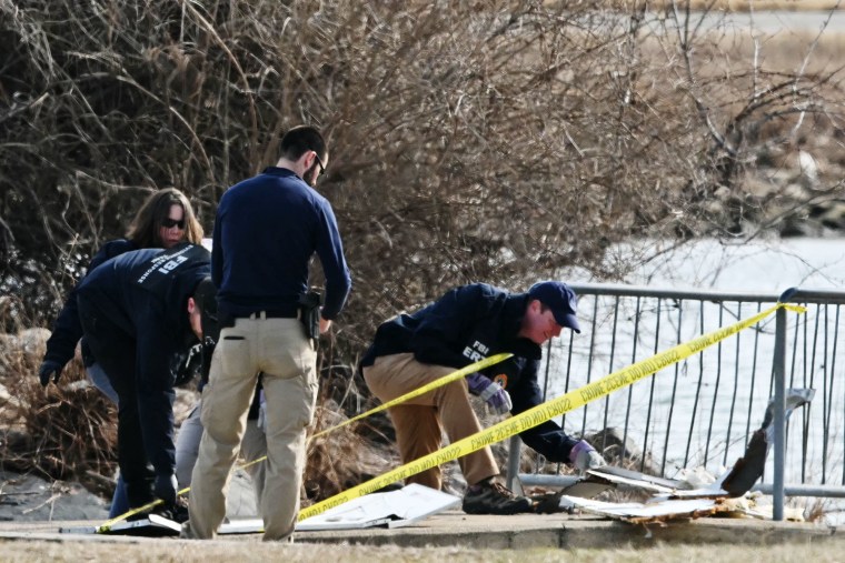 Investigators gather pieces of wreckage along the Potomac River on Jan. 30, 2025. 