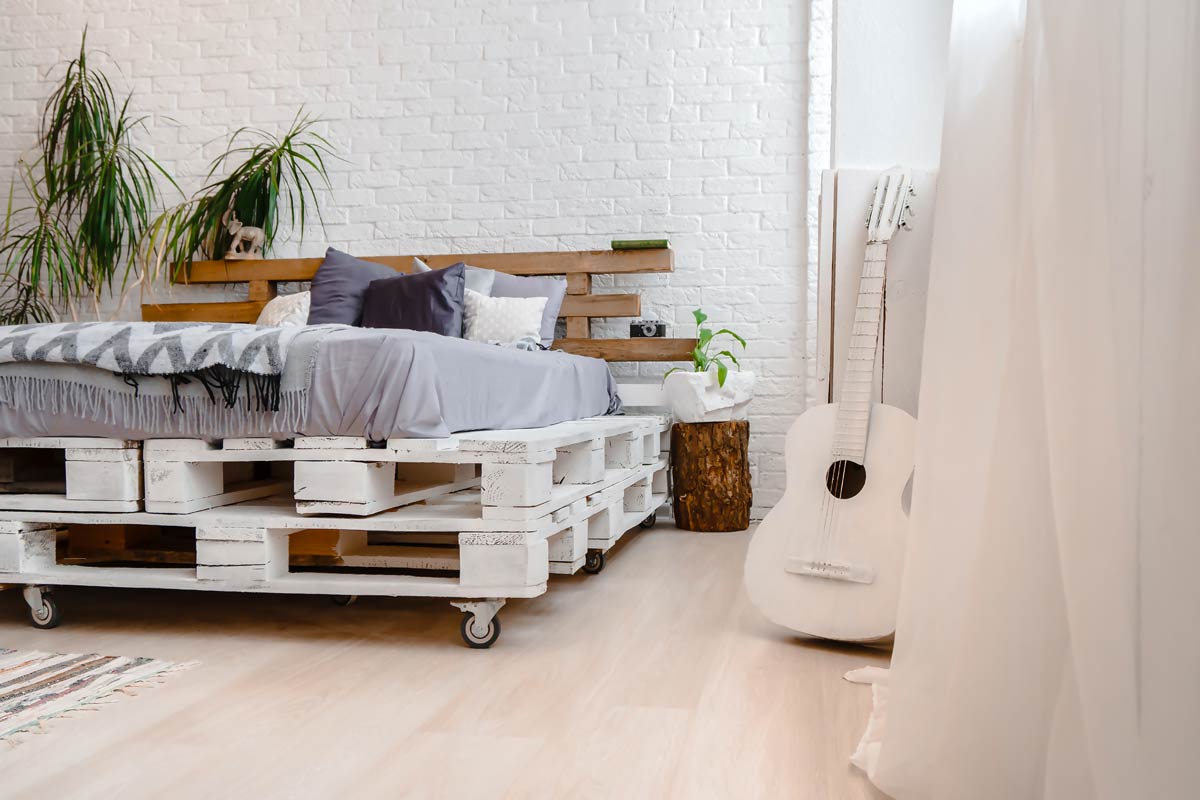 DIY bed and headboard made from wooden pallets.