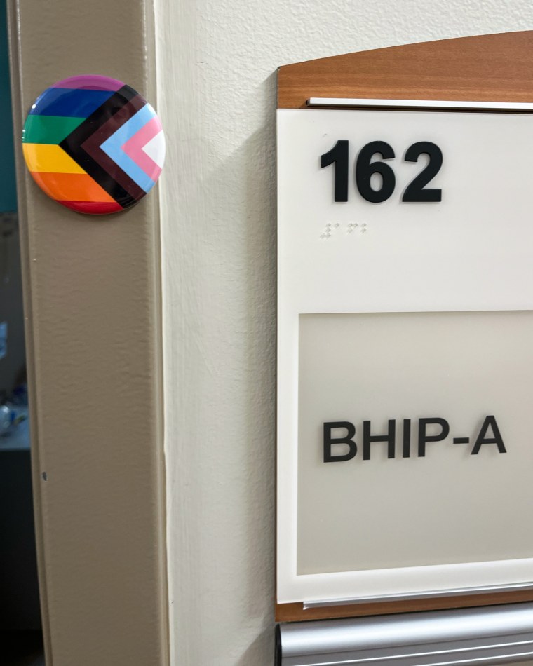 A pride pin displayed outside of an office