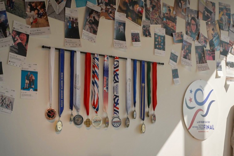 A wall with medals and printed photos.