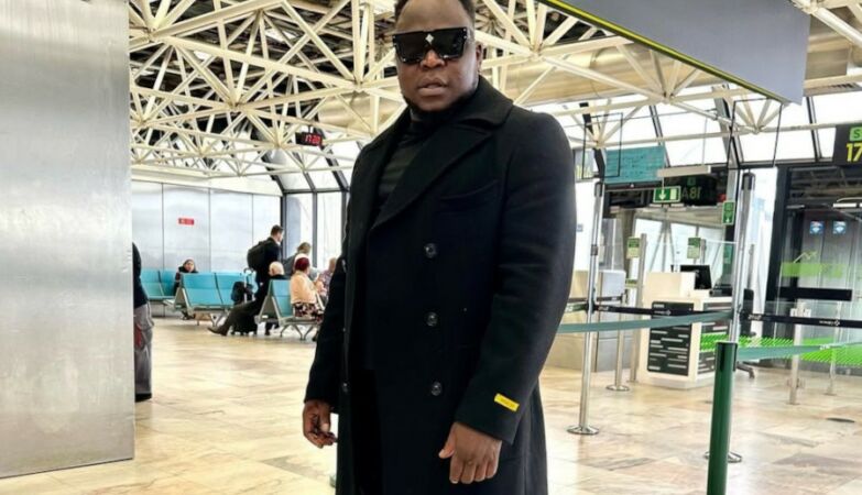 Singer Américo Gomes with dark glasses and dressed in black at an airport.
