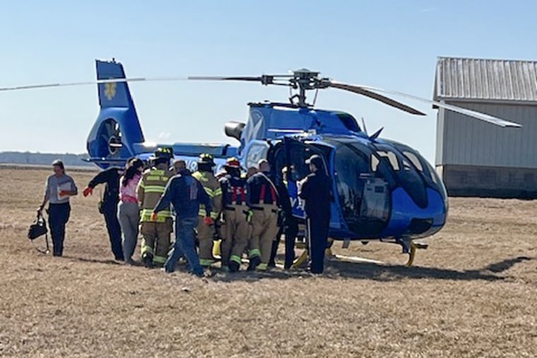 People gather around a helicopter outside