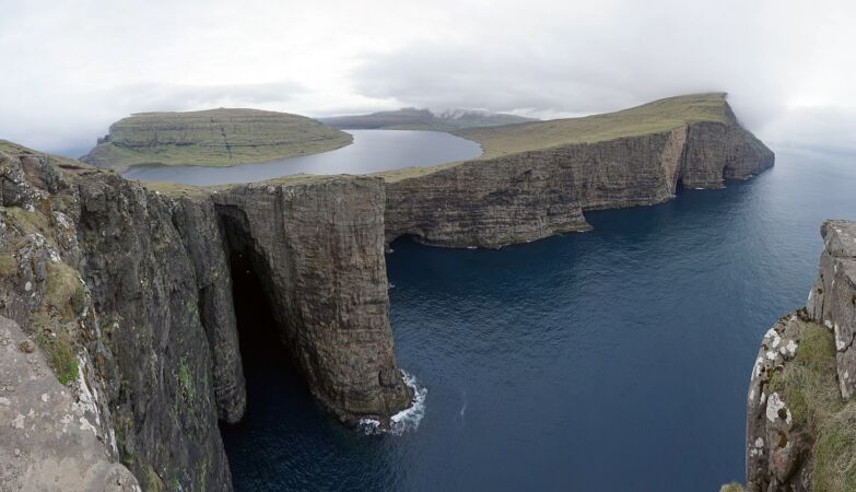 Lake on the Faroé Islands seems to hang over the ocean and arouses curiosity