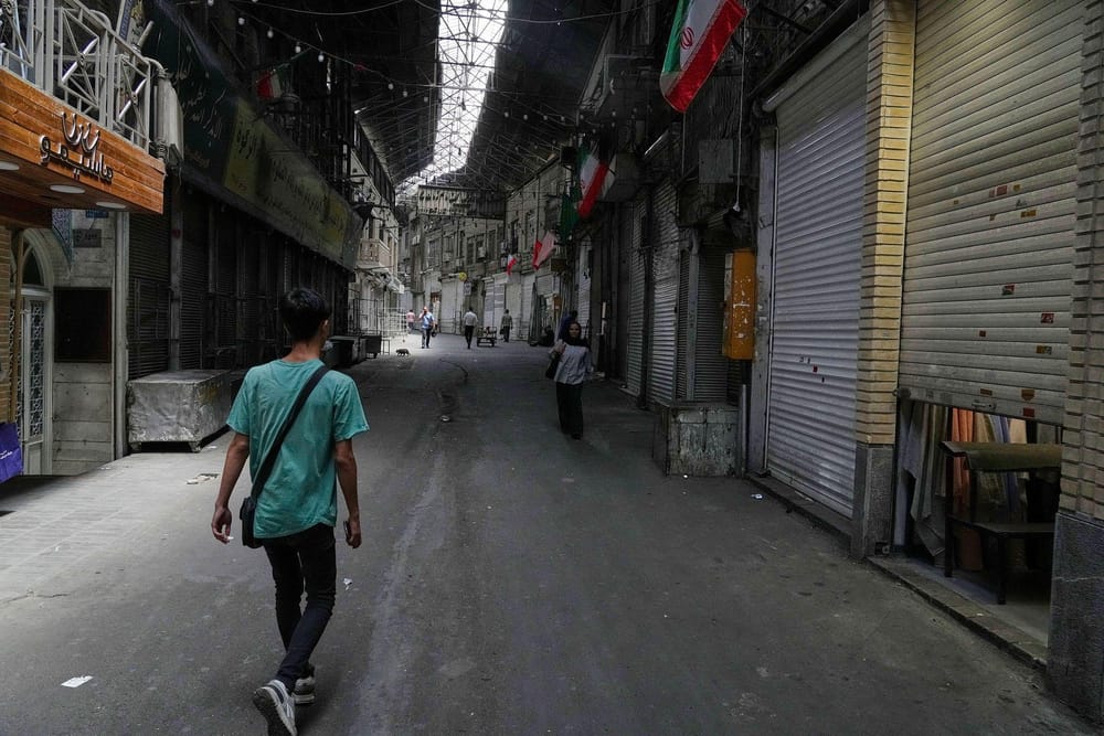 Few pedestrians walk along the large history of bazaar while the stores remain closed in Tehran, Iran (Vahid Salemi/AP)