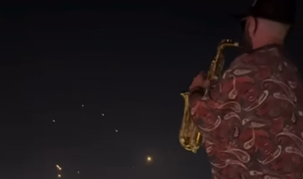 Saxophonist continues to play while missiles cross the skies on the border between Lebanon and Israel