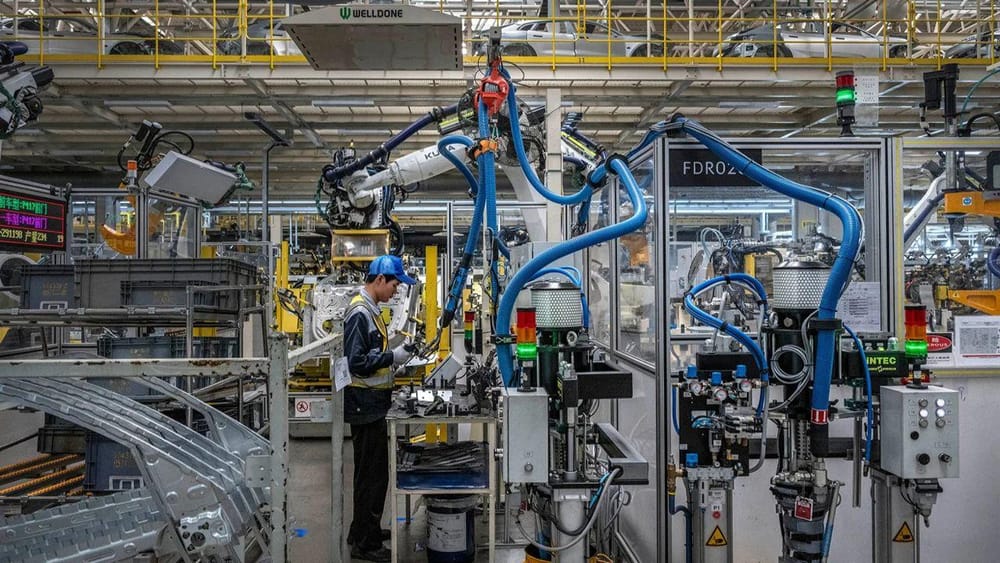 One worker controls a robotic arm on the production line of an electric vehicle factory in Ningbo, China, May 29 (Kevin Frayer/Getty Images)