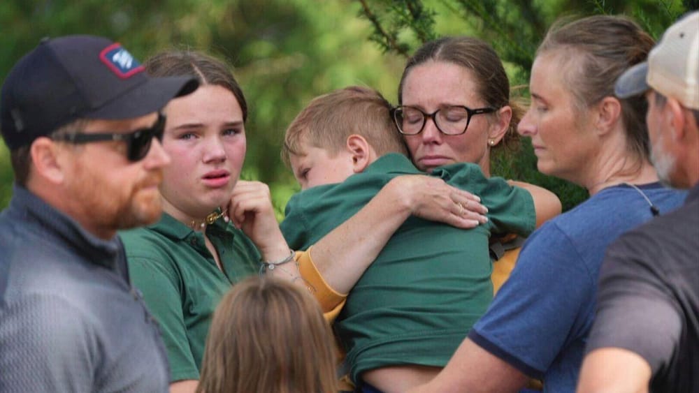A mother hugs her son after the shooting in Minneapolis (Alex Kormann/AP)