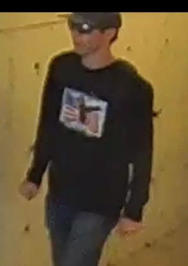 Man with cap, black shirt and sunglasses climbing the stairs