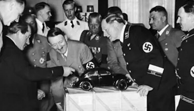 Ferdinand Porsche reveals the Volkwagen concept in the presence of a visibly enthusiastic Adolf Hitler, finding that the engine is in the car's suitcase.