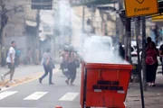 During a police operation against Comando Vermelho, bandits order the closure of businesses and use burning dumpsters to block the road on Rua Itapiru, in Catumbi.