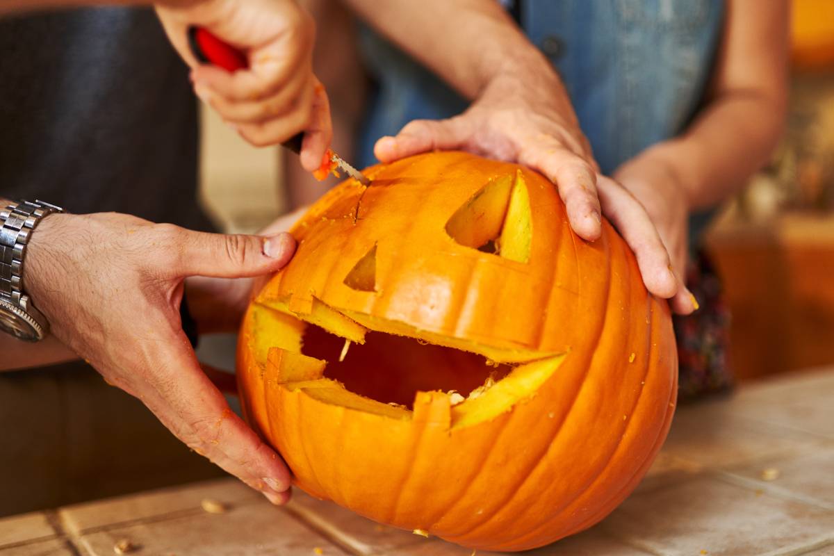 Hands carving pumpkin