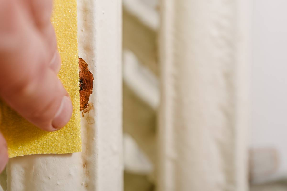 Cleaning rusty radiators with sandpaper