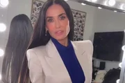 Demi Moore poses with her hair down and a white suit