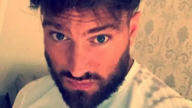 Photo of a younger Christopher Harkins. He looks directly into the camera.