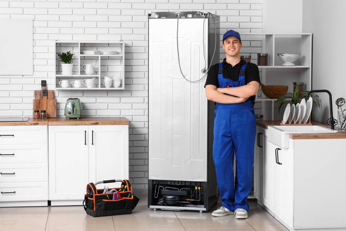 technician fixing fridge that leaks water