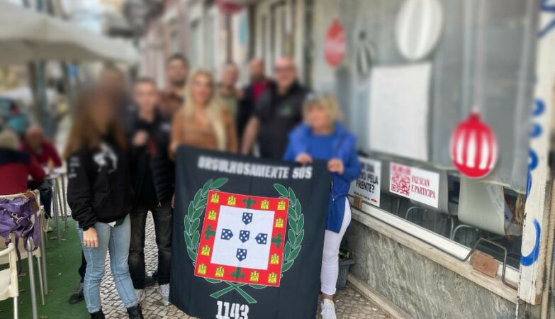 Members of the neo-Nazi Group 1143 holding a flag that proudly says alone.