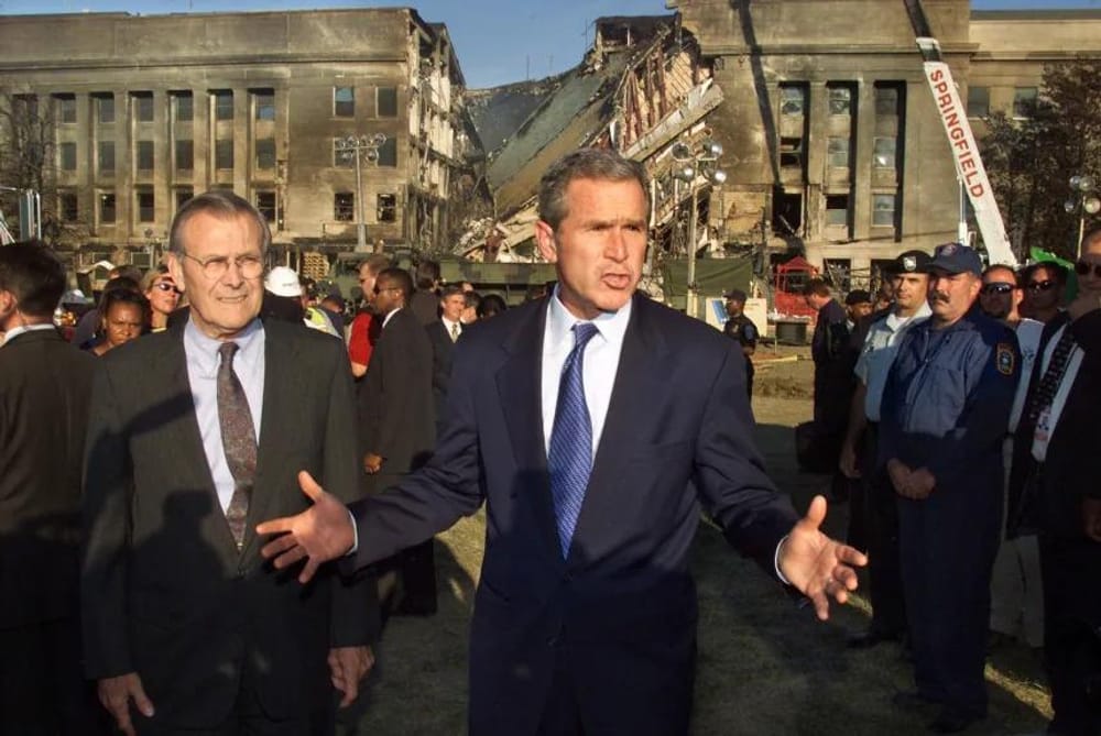 Defense Secretary Donald Rumsfeld, left, watches as President Bush speaks about the devastation at the Pentagon in Washington on September 12, 2001 (Pablo Martinez Monsivais/AP)