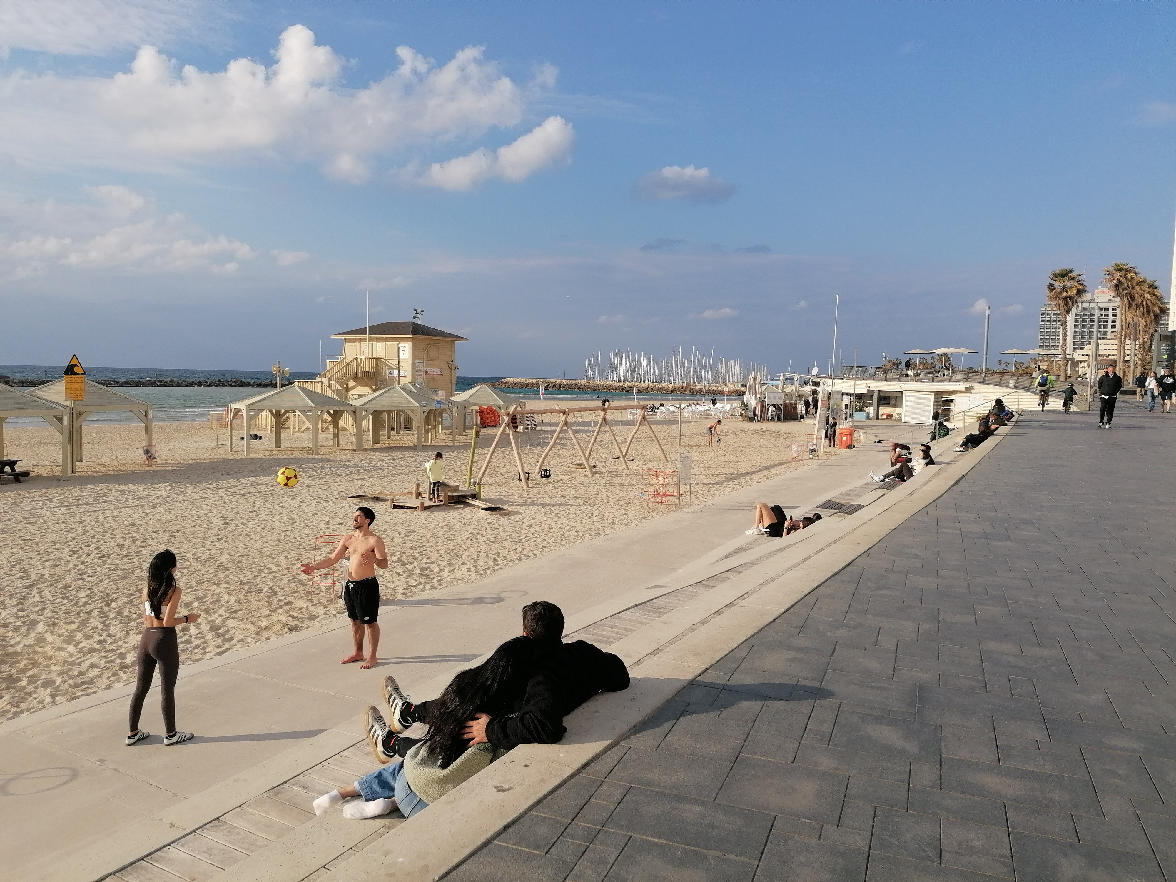 'Life must go on': Rackets, sunbathing and alarms on Tel Aviv beach