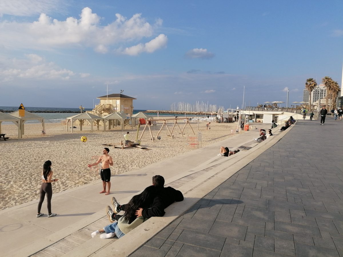 'Life must go on': Rackets, sunbathing and alarms on Tel Aviv beach