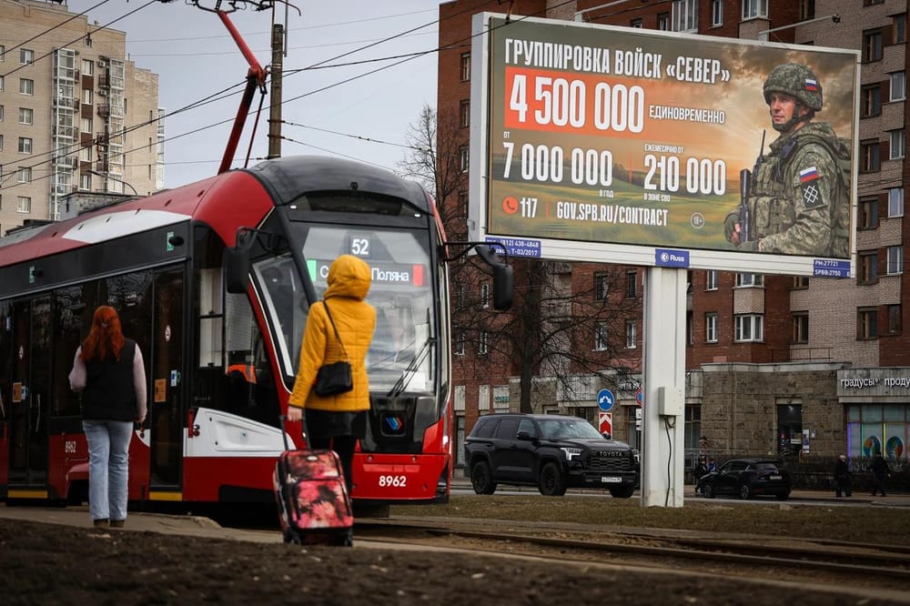 Residents gather at a tram stop in Saint Petersburg, in front of an information board advertising vacancies for military contractors in the Russian Armed Forces, on March 23 this year. (Artem Priakhin/SOPA Images/LightRocket/Getty Images)
