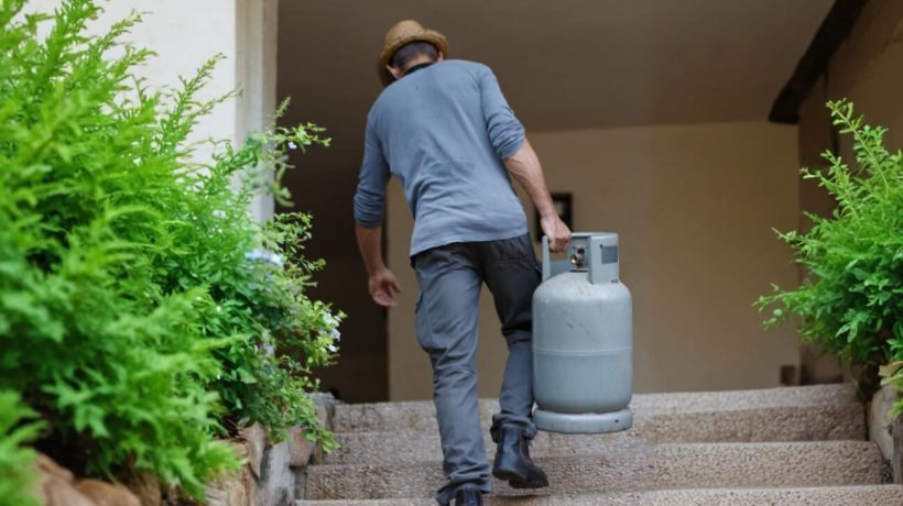 Homem a transportar botija de gás. Crédito: Freepik