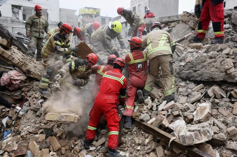 Rescue teams search for survivors in the rubble after an attack in southern Tehran, Iran, on March 13, 2026 (Sajjad Safari/AP)