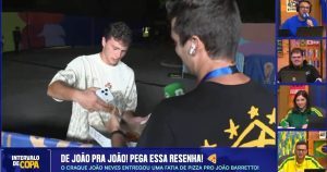 João Neves offers pizza to a Brazilian reporter who hadn't eaten for several hours